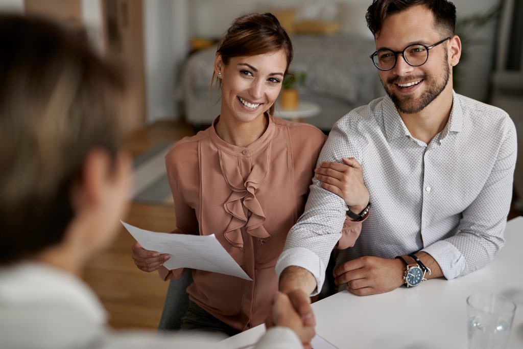 happy couple handshaking with their financial advisor after meeting